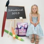 Schulkind sitzend mit Tafel